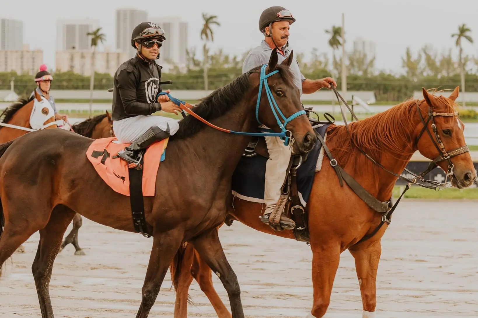 Two men riding race horses
